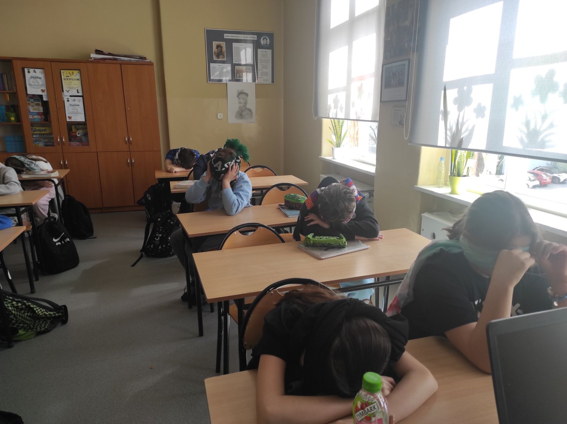 Zdjęcia przedstawiają uczniów w trakcie słuchania tekstu. 