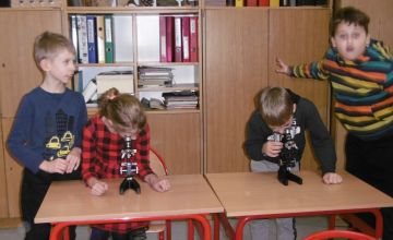 Uczniowie oglądają preparaty pod mikroskopem. 